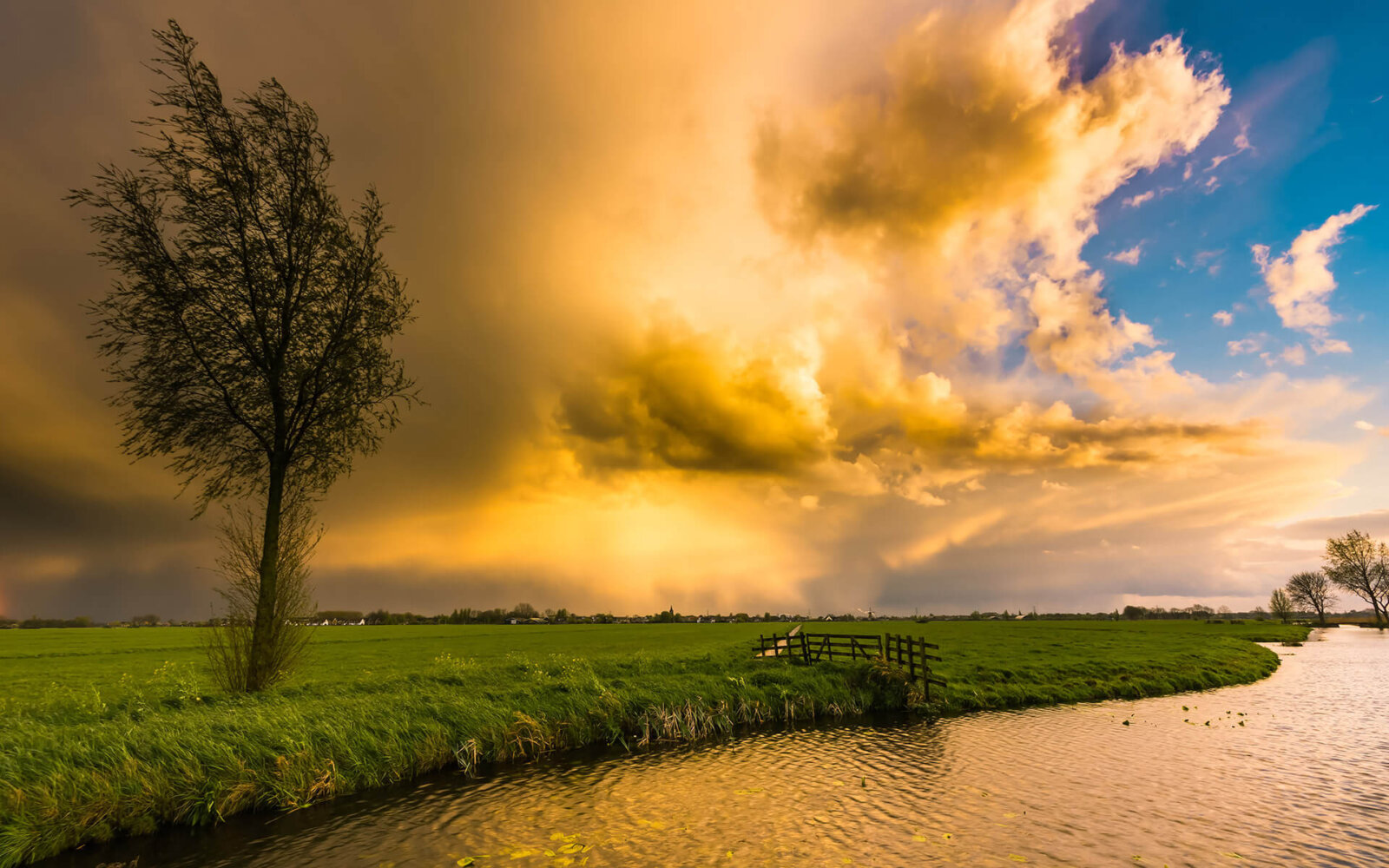 Rain clouds threaten over the Alblasserwaard during sunset.