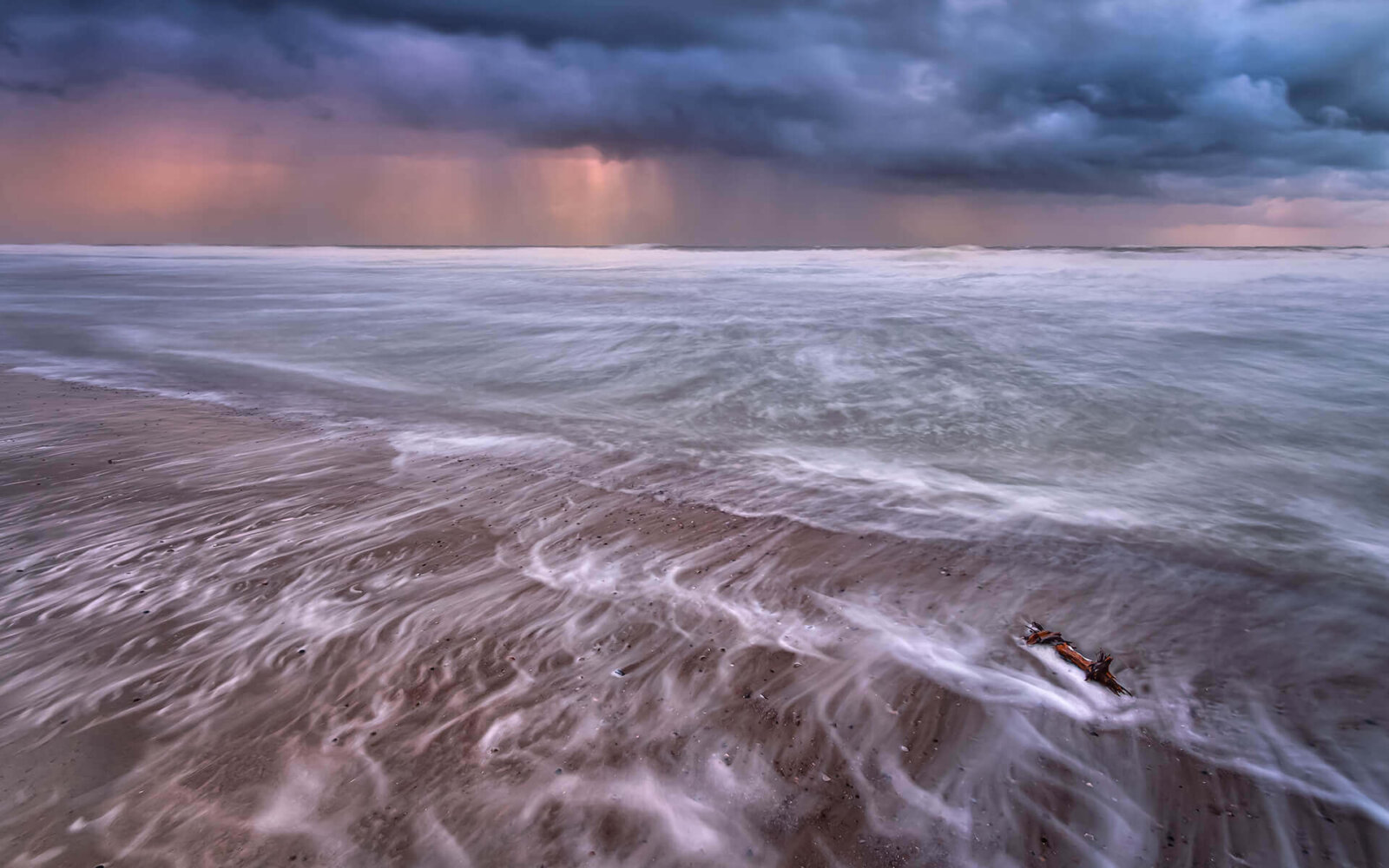 Seen from the beach at Domburg there is a heavy rain shower, making this photo lively but also serene, above the North Sea.