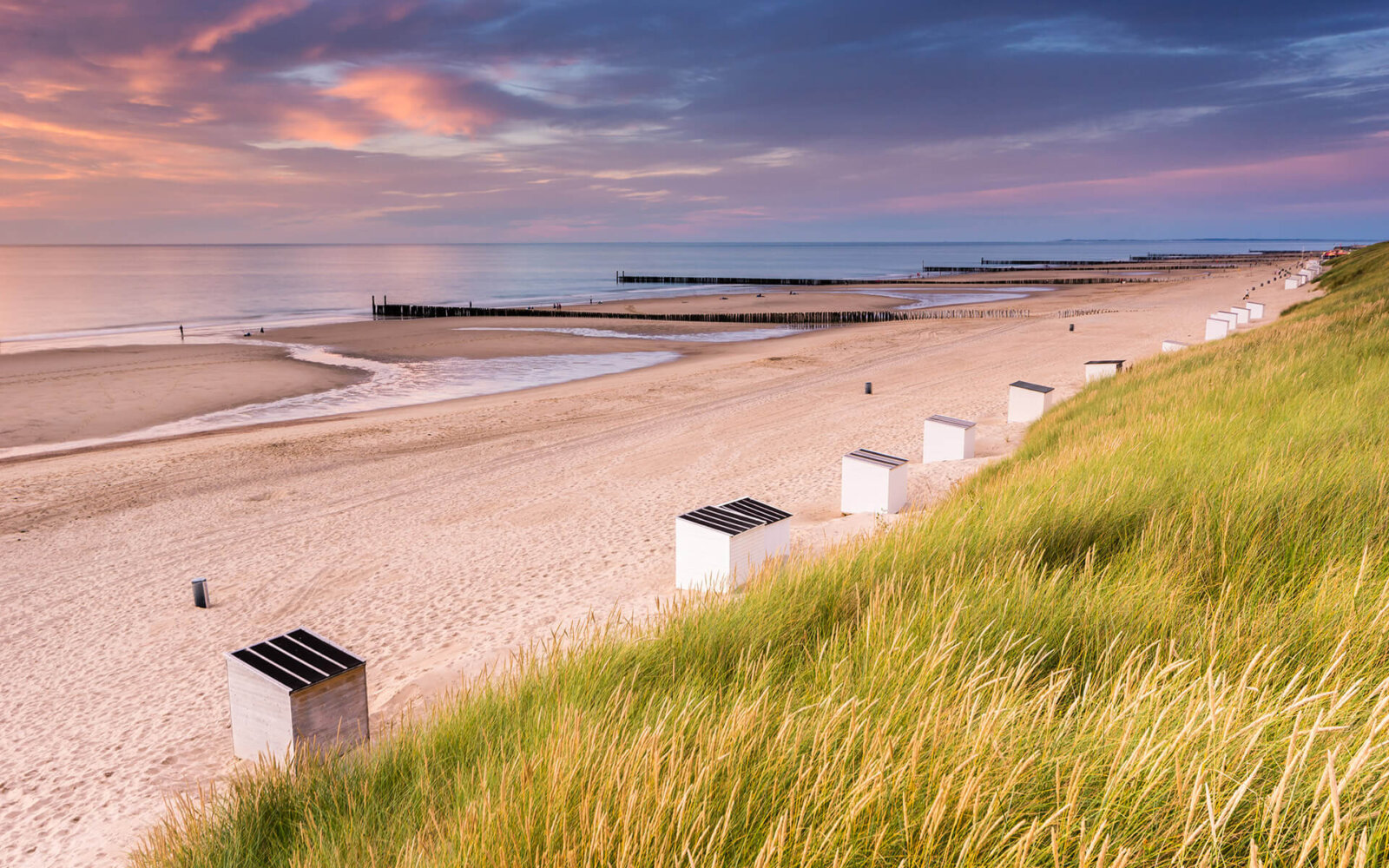 On a lovely summer evening a beautiful sunset over the dunes, beach and sea at Domburg.