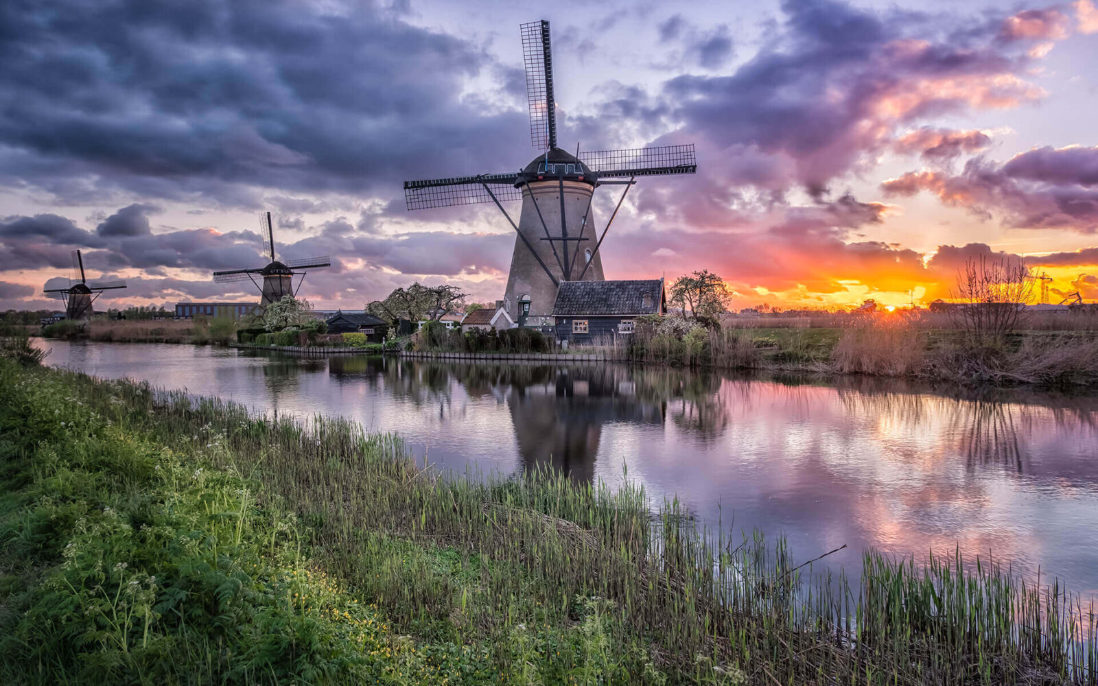 A sunset with reflections at the windmills of Kinderdijk.