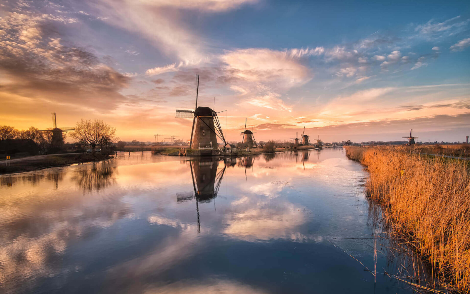 Kinderdijk On a great evening by the water, with beautiful clouds reflected at the windmills of Kinderdijk.