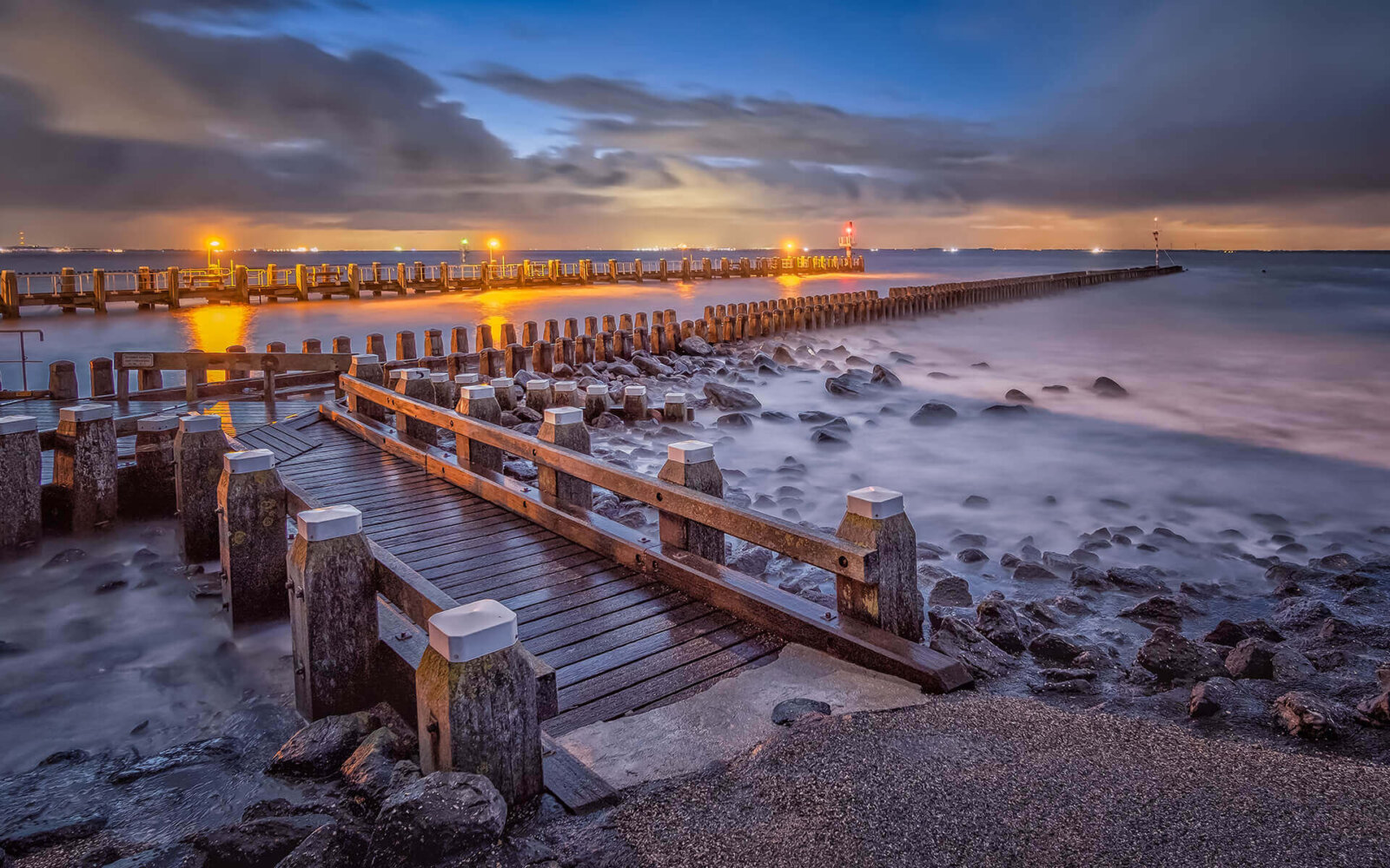 During the last hour of the night, even before sunrise, with lights on the jetties of the port of Vlissingen.