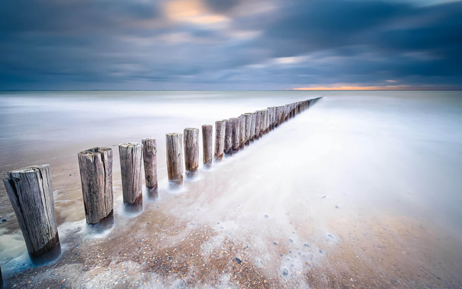 At the sea of glass on the beach, with a row of poles, near Dishoek.