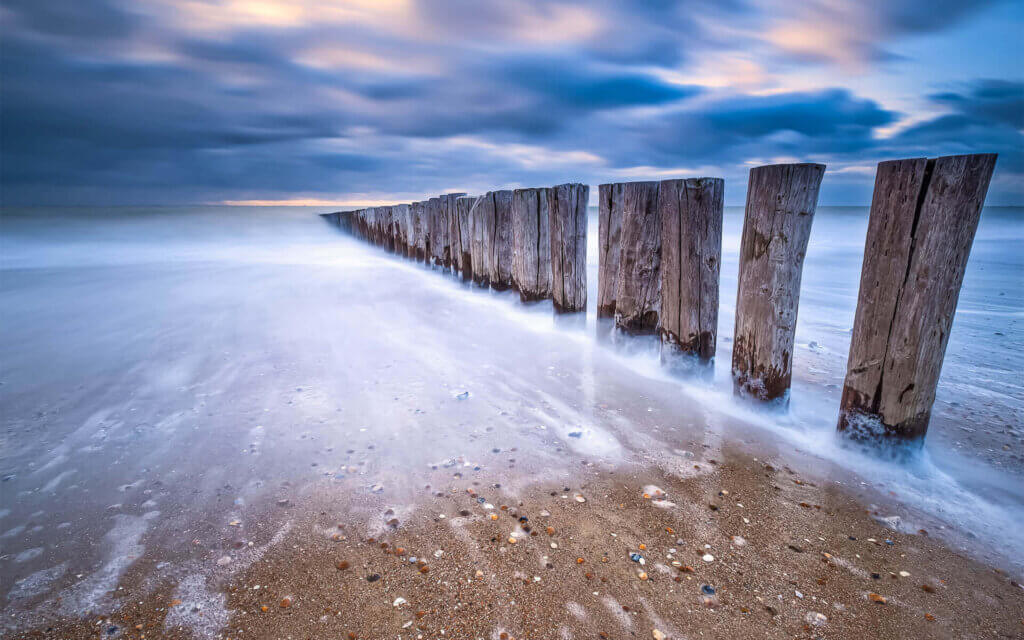 The sea as a mirror at a row of poles in Dishoek.