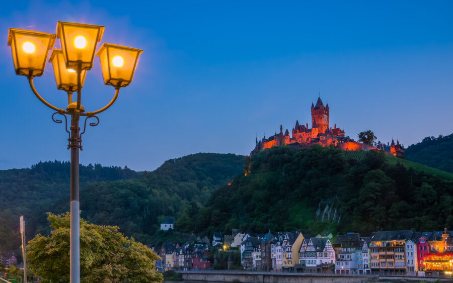 The illuminated castle of Cochem is clearly visible in the light of a lantern.