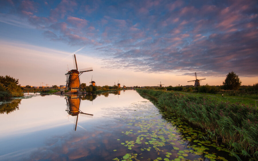 Kinderdijk Beautiful sunset at the windmills of Kinderdijk. The soft light is reflected, just like the windmills.