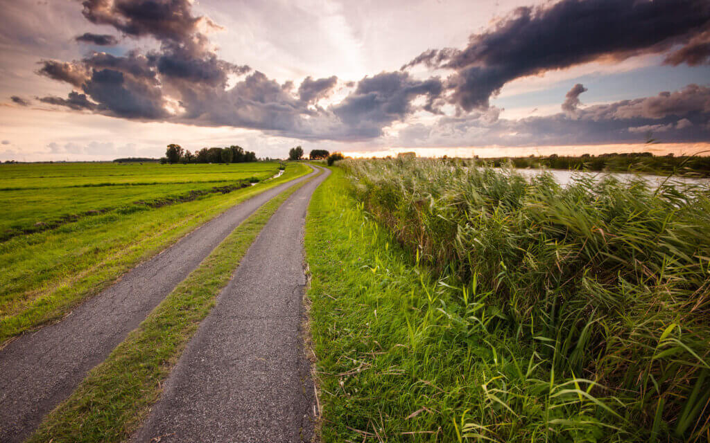 On a late summer day, at sunset, a beautiful cloudy sky above a hiker's path in De Donk.