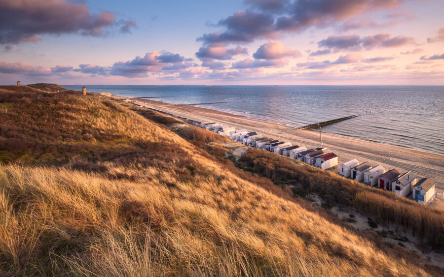 Just before the sun sets, it colors the dunes from brown to gold. The clouds follow suit in soft pastel shades above the coast of Dishoek.