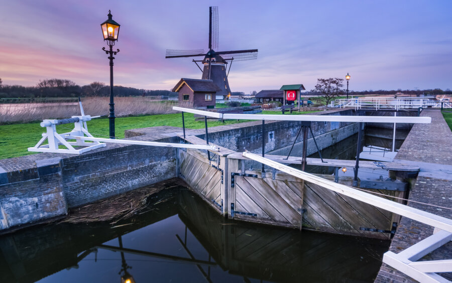 The windmill at the Zevenhuizense Verlaat at sunset. The lock lights have just come on.