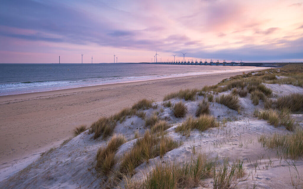 Beautiful sunrise on the dunes of the coastline near Kamperland, with a view of the sea, the beach, and the Neeltje Jans storm surge barrier.