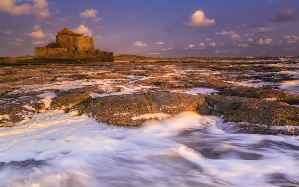 Sunset at Fort Vauban on the Ambleteuse coastline. Beautiful layered photo with sea, rocks, and the fort.