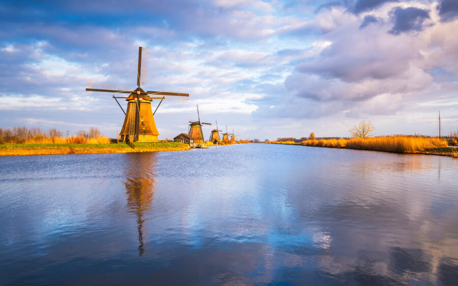 Kinderdijk The famous windmills of Kinderdijk at the beginning of a beautiful evening in the Alblasserwaard. Beautiful reflection of the sky and windmill in the water.