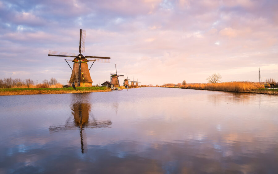 Kinderdijk Beautiful, peaceful, and calm spring sunset at the Kinderdijk windmills. Lovely reflection of the windmill and the clouds in the stream.